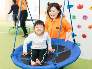 子どもが円形ブランコに乗って揺れている様子