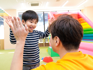子どもが指導者とハイタッチしている様子