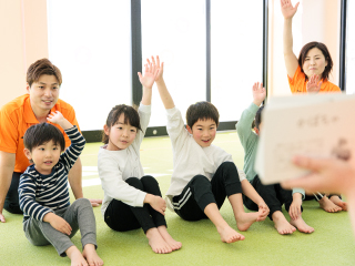 指導者が大きな紙を使って子どもたちに説明している様子