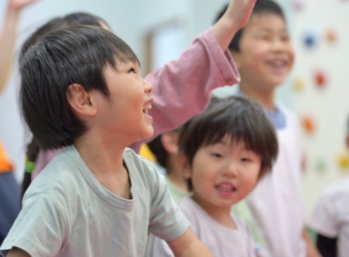 子どもが先生の顔を見ながら笑っている様子