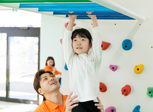 子どもが天井から吊るされた器具で体を支えている様子